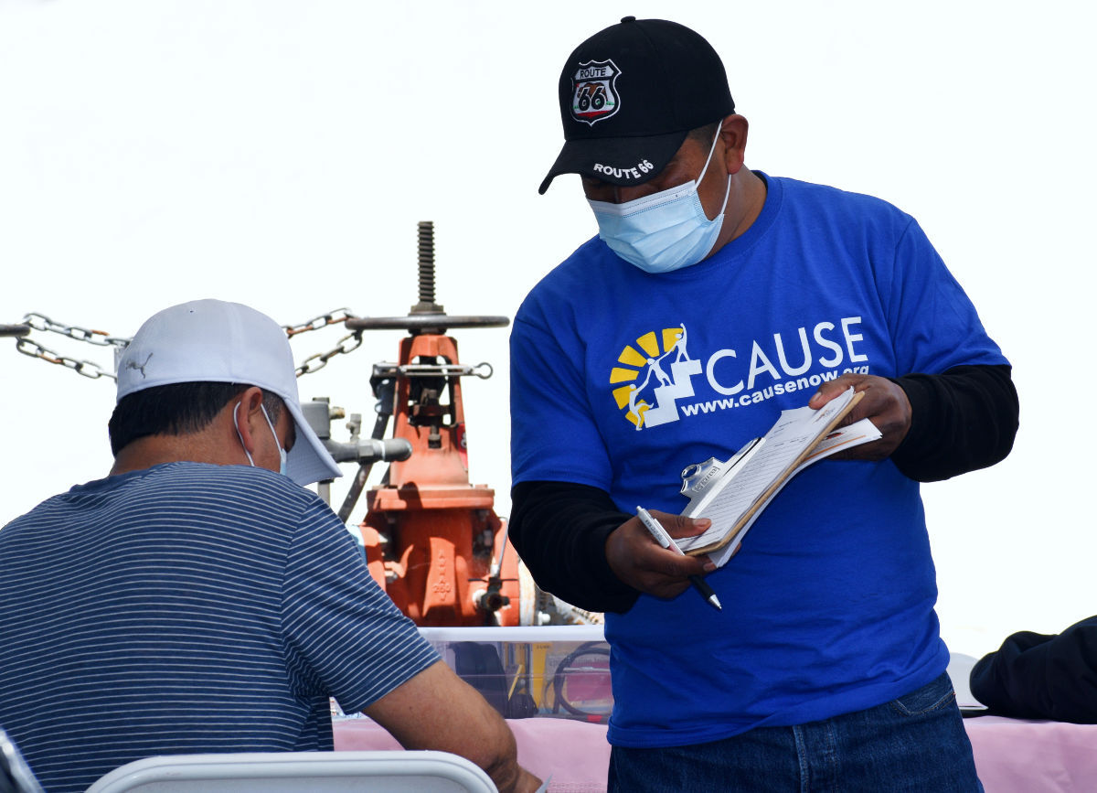 A member for CAUSE presents post vaccine information at a mobile clinic in Santa Maria